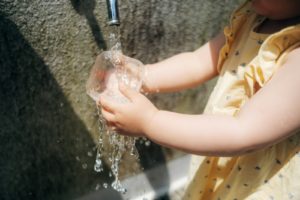 a person pouring water into a sink